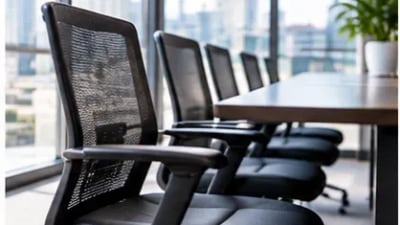 Fileira de cadeiras de escritório com encosto de tela preta em sala de reunião envidraçada